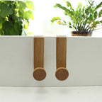 White iron and rubber wood wardrobe hook by Cavira, powder-coated for durability, perfect for bedroom or cabinet organization.