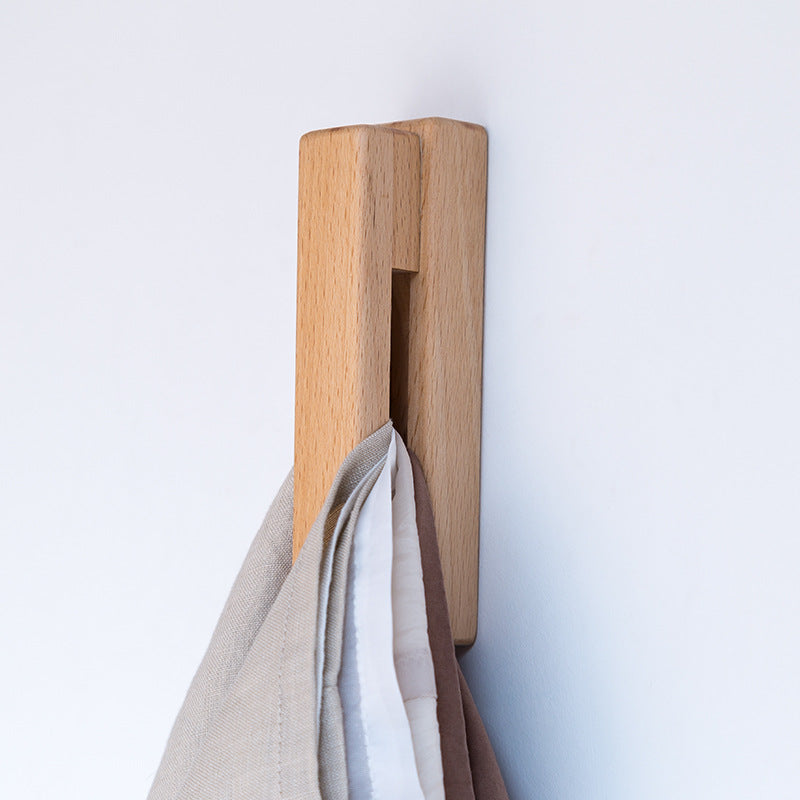 Black walnut and eucalyptus adhesive single hook by Cavira, no-drill design, suitable for bathroom, entryway, or bedroom.