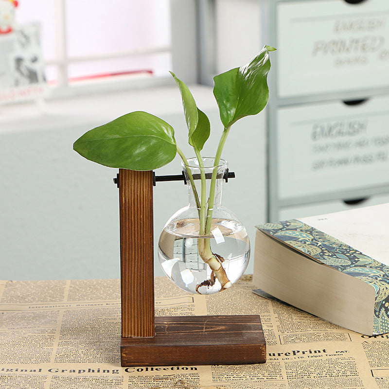Transparent glass vase with wooden frame by Cavira, minimalist desktop flower vase for home decor and shelf styling.