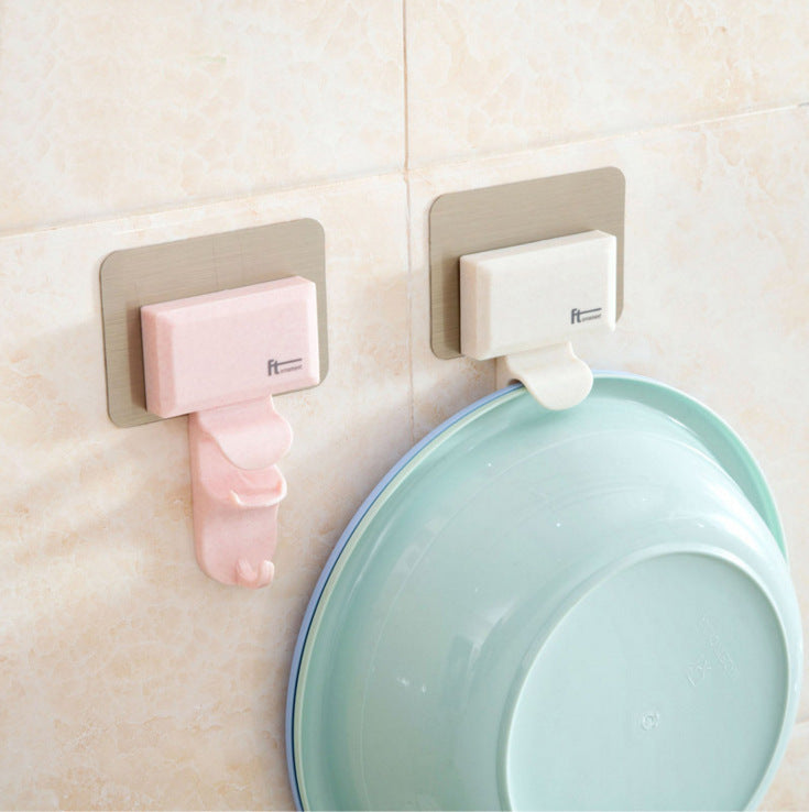 Pink and beige Cavira seamless wall-mounted washbasin hook rack made of ABS, punch-free bathroom basin hanger attached to a wall.