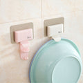 Pink and beige Cavira seamless wall-mounted washbasin hook rack made of ABS, punch-free bathroom basin hanger attached to a wall.