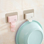 Pink and beige Cavira seamless wall-mounted washbasin hook rack made of ABS, punch-free bathroom basin hanger attached to a wall.