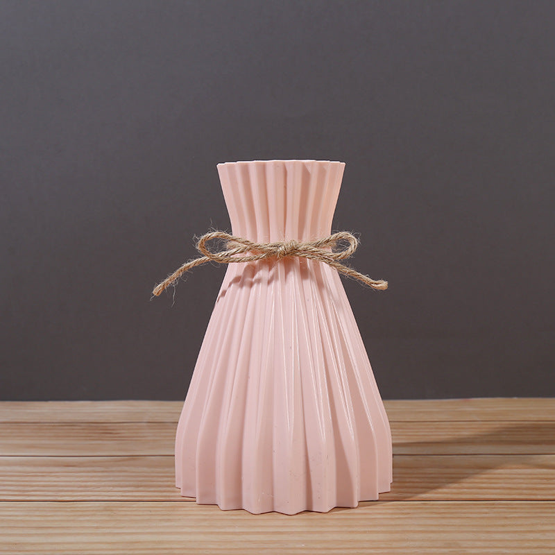 Minimalist paper vase with twine detail by Cavira, showcasing a creative plastic flower arrangement for home decor.