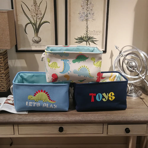 Canvas folding dinosaur storage basket by Cavira with embroidered cartoon dinosaur, ideal for kids' toys and stationery in nursery or bedroom