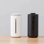 Portable glass French press by Cavira with borosilicate glass carafe, white and black frame, for coffee and tea brewing at home or travel.