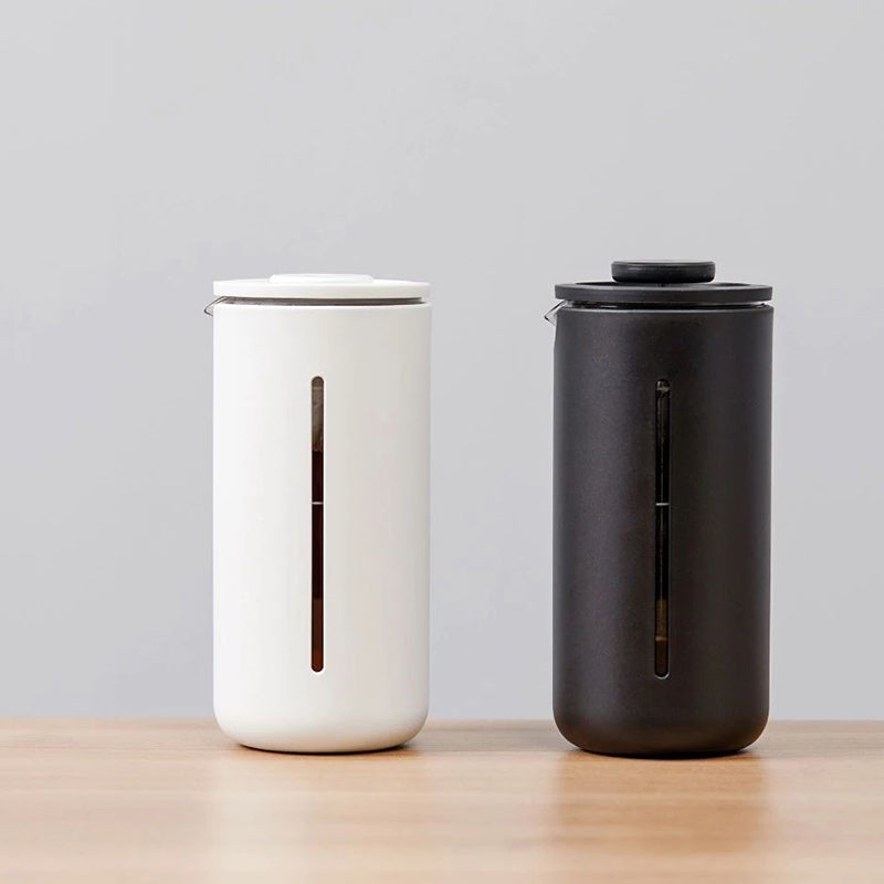 Portable glass French press by Cavira with borosilicate glass carafe, white and black frame, for coffee and tea brewing at home or travel.