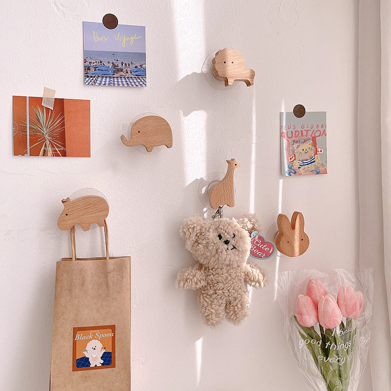Wooden animal-shaped wall hooks by Cavira featuring giraffe, hippo, lion, rabbit, and elephant for kids' rooms or nurseries.