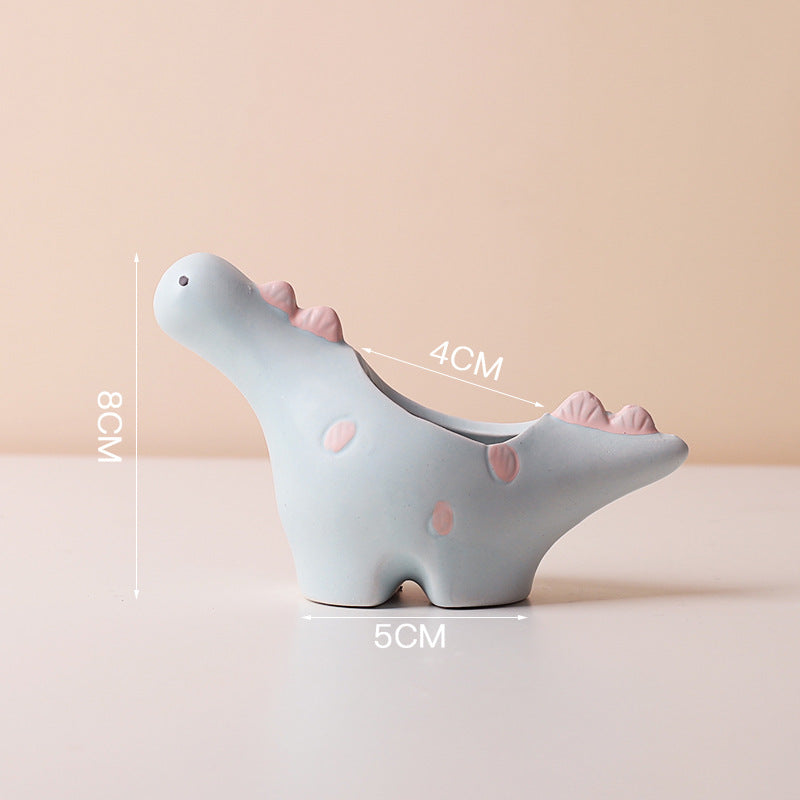 Ceramic succulent pot by Cavira featuring elephant, dinosaur, and flower designs, perfect for small plants on desk or shelf.
