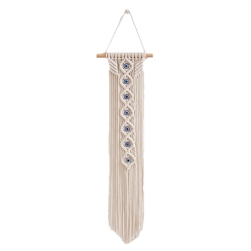 Handwoven cotton rope evil eye wall hanging tapestry with tassels and beech wood rod, perfect for boho bedroom or living room décor.