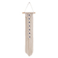 Handwoven cotton rope evil eye wall hanging tapestry with tassels and beech wood rod, perfect for boho bedroom or living room décor.