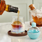 Colorful silicone ice ball mold by Cavira, creates round ice spheres for whiskey and cocktails, made from food-grade PET and silicone.