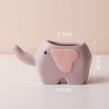 Cute ceramic succulent pot by Cavira featuring elephant, dinosaur, or flower designs, perfect for desk or shelf décor.