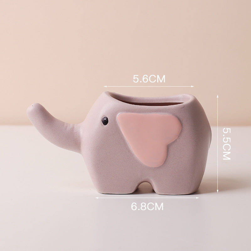 Cute ceramic succulent pot by Cavira featuring elephant, dinosaur, or flower designs, perfect for desk or shelf décor.