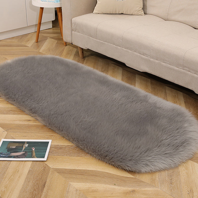 Oval acrylic plush rug by Cavira with soft imitation wool pile in various sizes and colors, ideal for bedrooms and living areas.