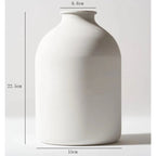 White matte metal vase with unique sculptural shape for dried flowers, ideal for home or wedding décor, shown with pampas grass.