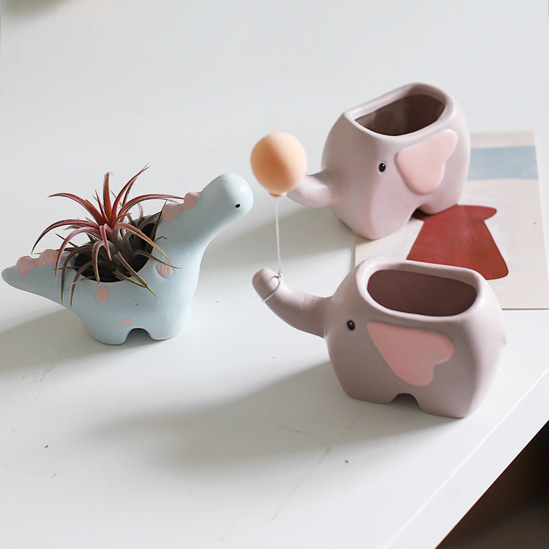 Ceramic succulent pot by Cavira featuring elephant, dinosaur, and flower designs, perfect for small plants on desk or shelf.