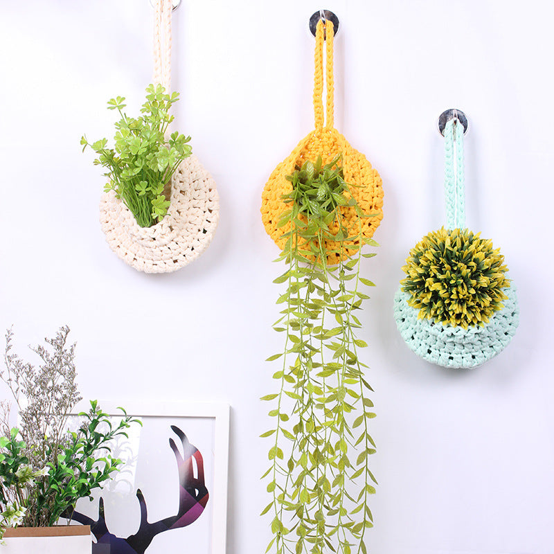 Handwoven boho cotton rope wall hanging net basket with woven flower design, used for storage or decor in home, bedroom, or living room.