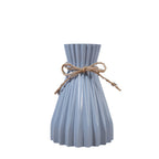 Cavira minimalist folded paper vase with twine detail, designed for creative plastic flower arrangements, ideal for home decor.
