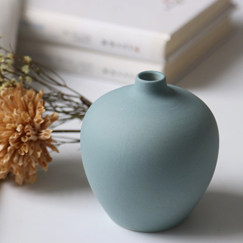 Set of four white porcelain ceramic vases by Cavira, modern minimalist design for fresh flower arrangements and home decor.