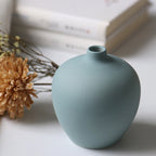Set of four white porcelain ceramic vases by Cavira, modern minimalist design for fresh flower arrangements and home decor.