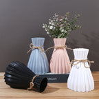 Minimalist folded paper vase with twine detail by Cavira, designed for creative plastic flower arrangements and home decor.