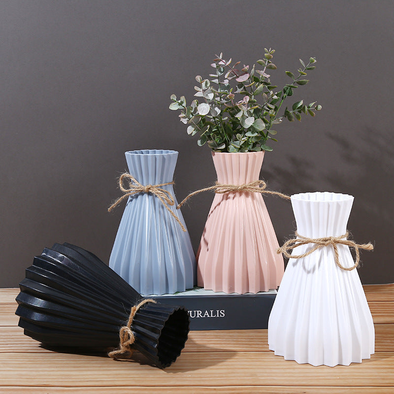Minimalist folded paper vase with twine detail by Cavira, designed for creative plastic flower arrangements and home decor.