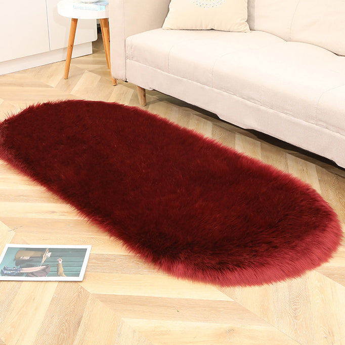 Oval acrylic plush rug by Cavira with soft wool pile in various colors, suitable for bedroom, living room, or bedside.