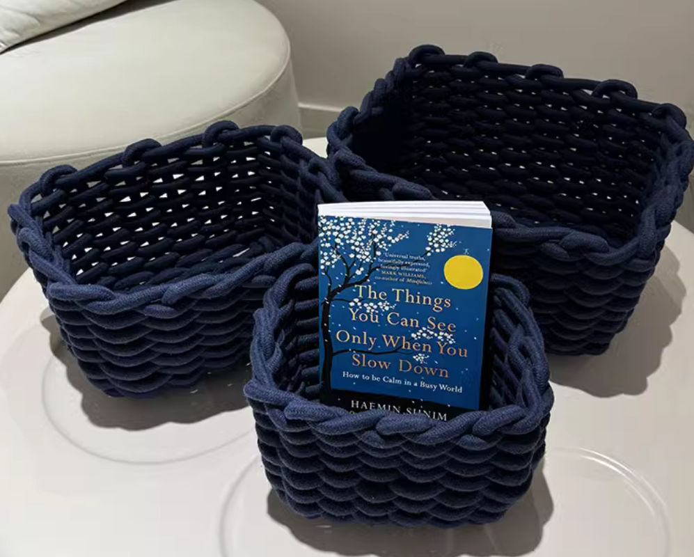 Set of three hand-woven cotton rope storage baskets in ink blue, ideal for living rooms, bedrooms, and bathrooms.