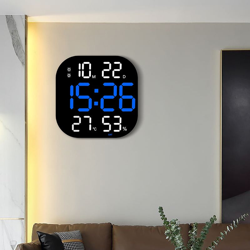 LED acrylic smart wall clock by Cavira showing digital time display, thermometer, and night light in a modern living room setting.