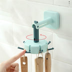 Cavira rotary multi-row adhesive wall hook in black, mounted on a kitchen wall, showing its punch-free, strong sticky design for organization.