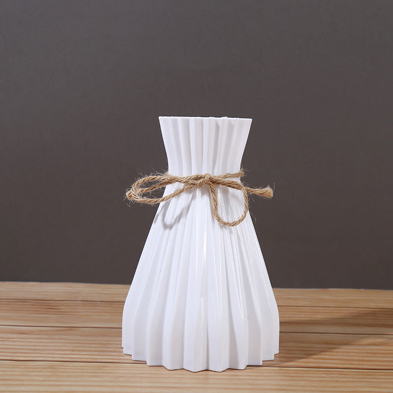 Minimalist folded paper vase with twine detail by Cavira, designed for creative plastic flower arrangements and home decor.