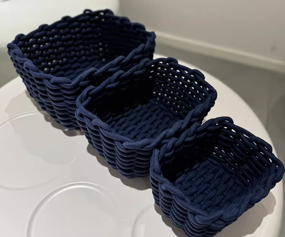 Set of three Cavira hand-woven cotton rope storage baskets in ink blue, nesting design for living room, bedroom, or bathroom.