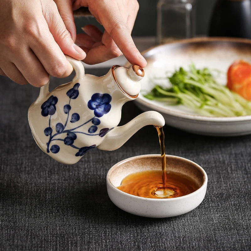 Cavira ceramic oil and vinegar dispenser bottle with auto-open lid, 150ml, in blue, white, black for kitchen condiments.