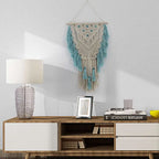 Blue bohemian macramé wall tapestry with cotton tassels and wooden stick for home or wedding decor, crafted by Cavira.