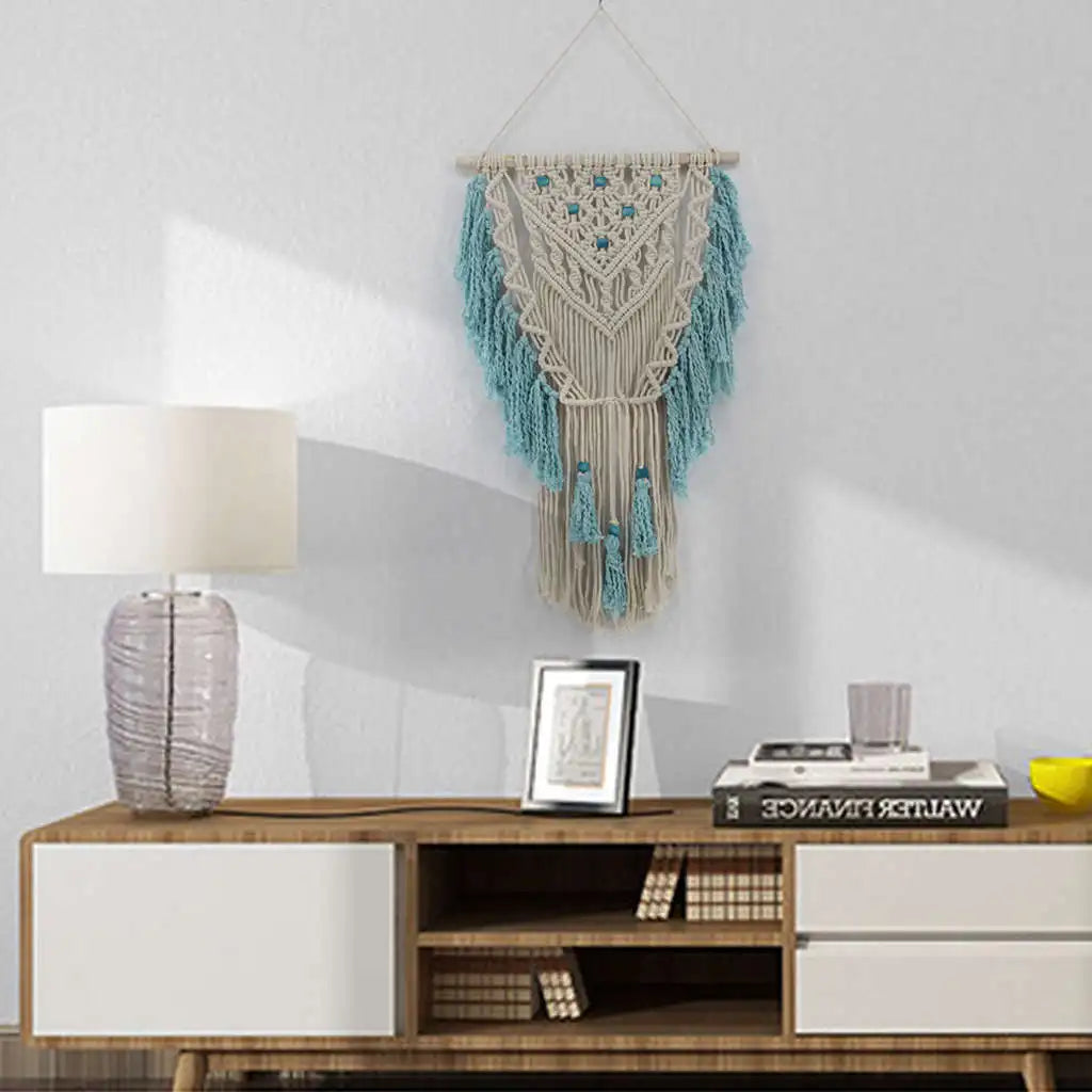 Blue bohemian macramé wall tapestry with cotton tassels and wooden stick for home or wedding decor, crafted by Cavira.