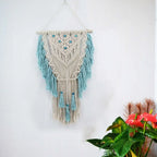Blue bohemian hand-knotted macramé wall tapestry with cotton tassels and wooden stick for home and wedding decor.