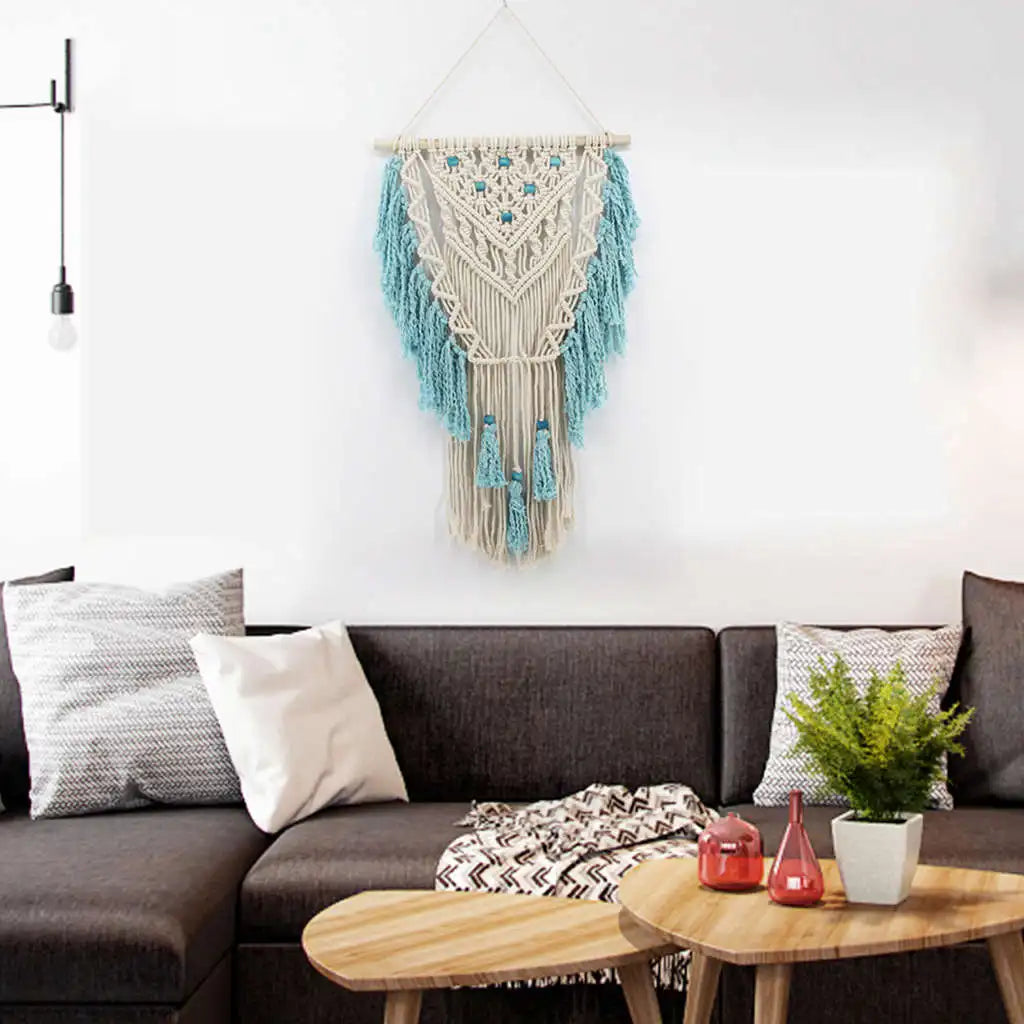 Blue bohemian hand-knotted macramé wall tapestry with cotton tassels and wooden stick for home or wedding decoration.