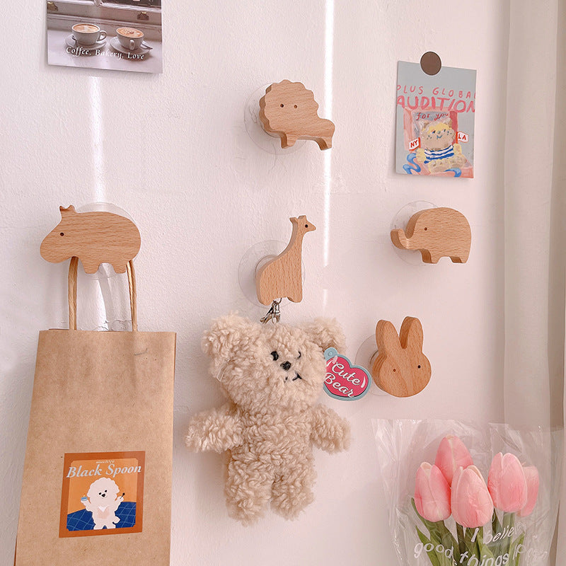 Wooden animal-shaped wall hooks by Cavira featuring giraffe, hippo, lion, rabbit, and elephant for kids' rooms and nurseries.