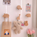 Wooden animal-shaped wall hooks by Cavira featuring giraffe, hippo, lion, rabbit, and elephant for kids' rooms and nurseries.