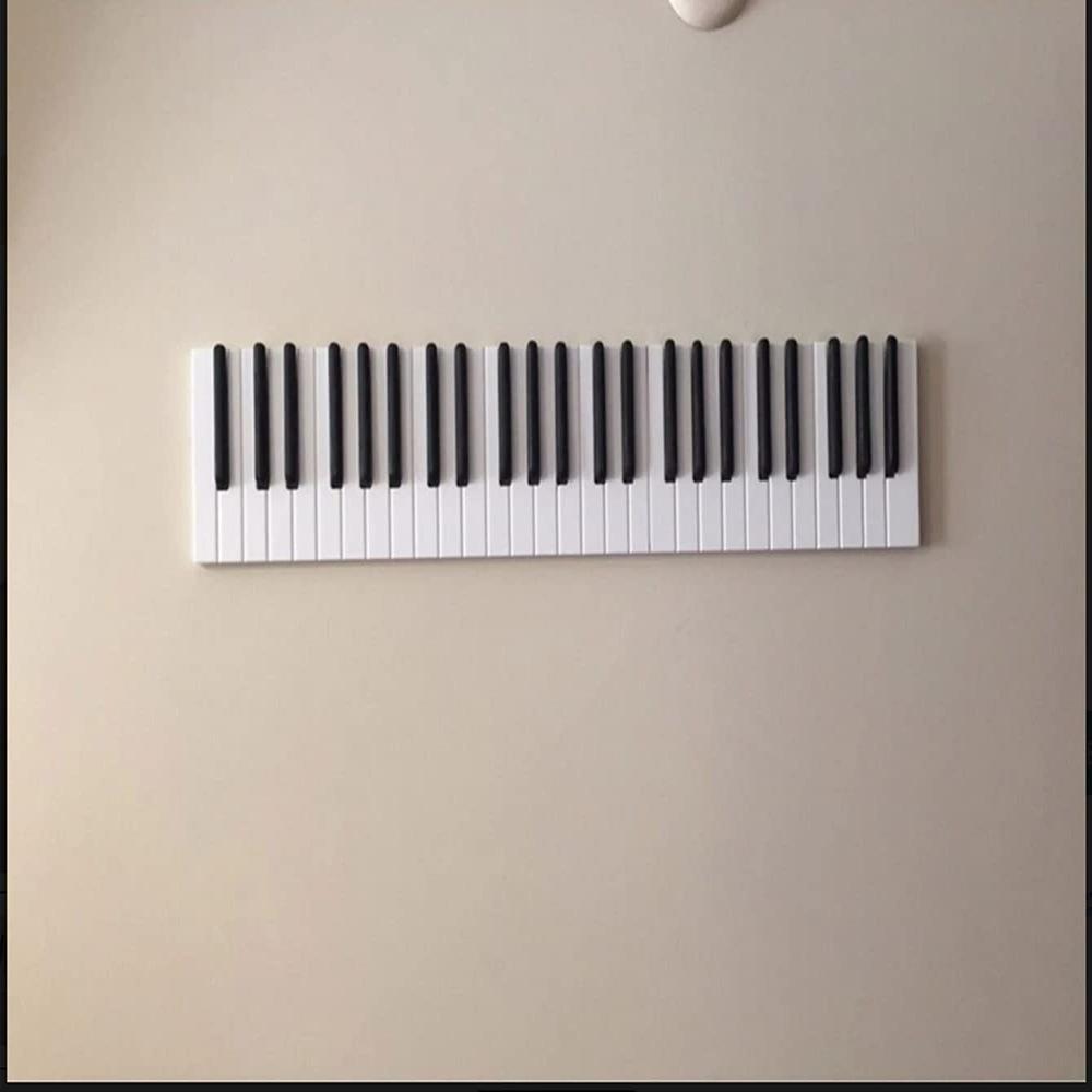 Wooden piano keyboard wall hook by Cavira in small, medium, and large sizes, perfect for entryways, bedrooms, and music rooms.